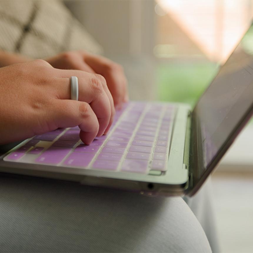 Hands typing on laptop.
