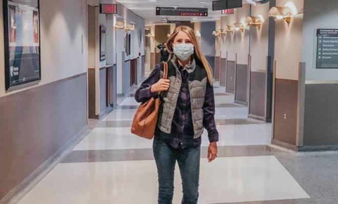 Una mujer camina por el pasillo de un hospital.